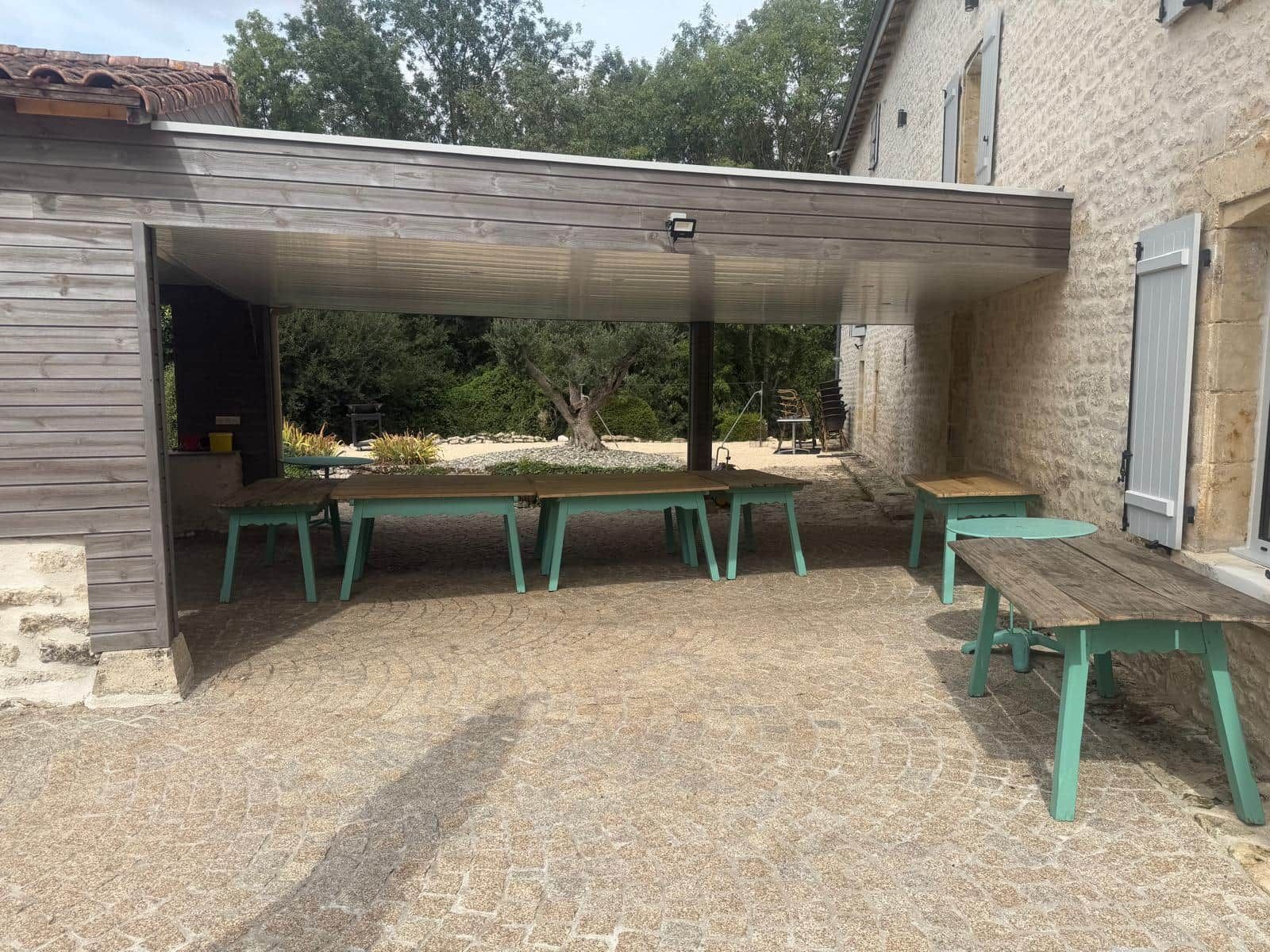 Een overdekt terras met een zithoek.