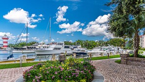 A marina with boats docked, a lighthouse, and a landscaped area with flowers. - Sea Pines Townhome | Walk to Harbour Town, Pool & Bike Trails (Hilton Head Island)