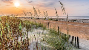 A beach with tall grasses and a wooden fence. - Sea Pines Townhome | Walk to Harbour Town, Pool & Bike Trails (Hilton Head Island)