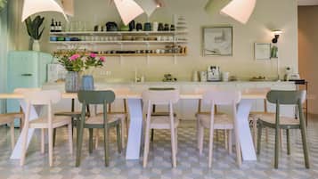 Una cocina moderna con una isla central, sillas blancas y piso estampado.