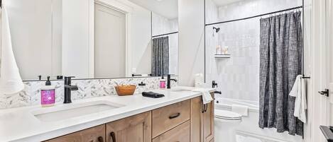 Une salle de bain moderne avec un meuble-lavabo à deux vasques, une douche avec une porte en verre et un sol carrelé en marbre.