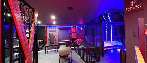 A modern interior with a bar area, seating, and a visible sign for 'LUXXX.EU APARTMENT'.