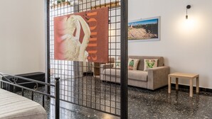 A hotel lobby with a black and white striped sofa, a small wooden table, a metal gate, and a framed picture on the wall. - La Casa di Nonna Anna by Wonderful Italy (Syracuse)