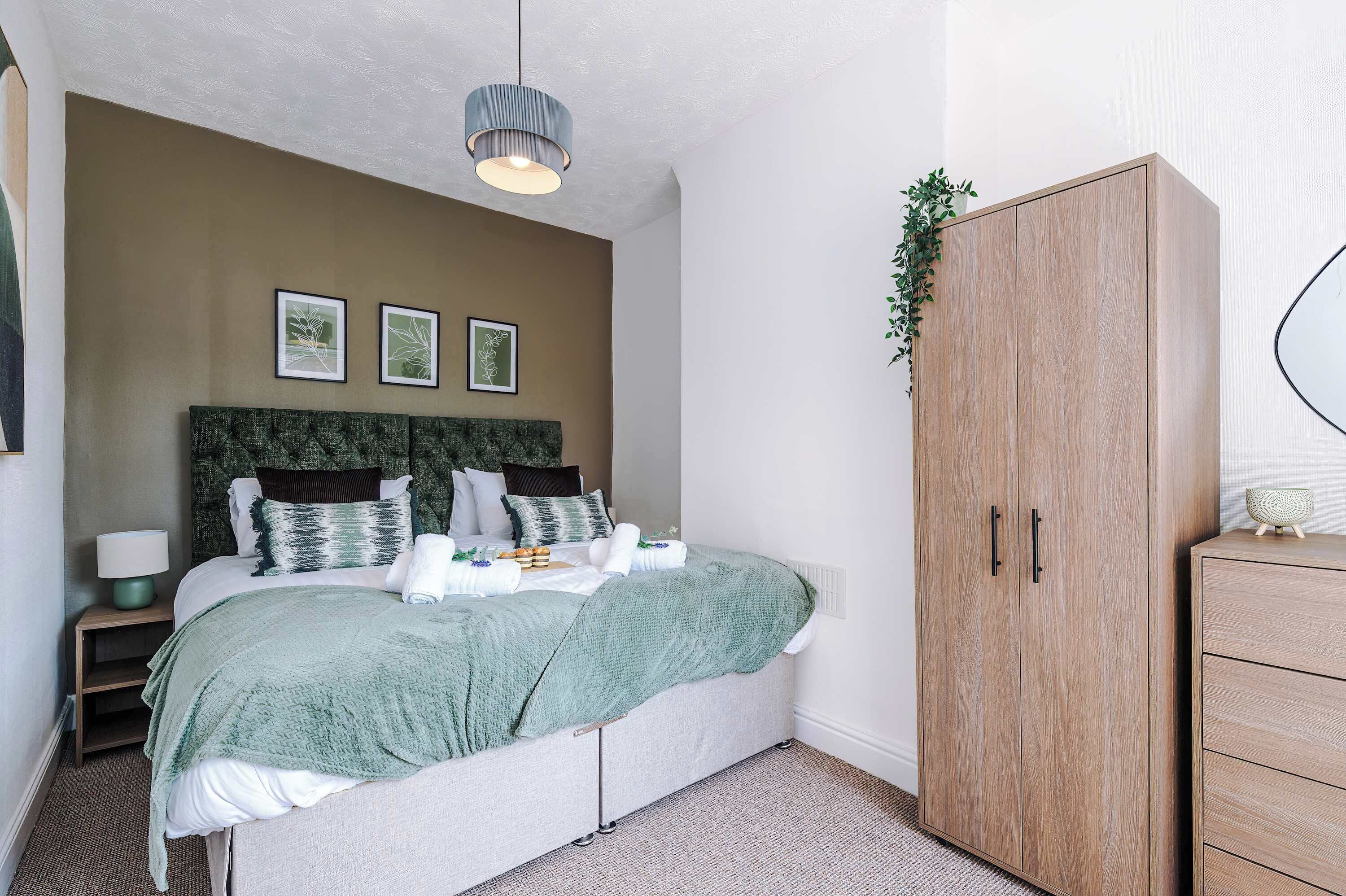 A neatly arranged bedroom with a bed, bedside table, and a wardrobe.