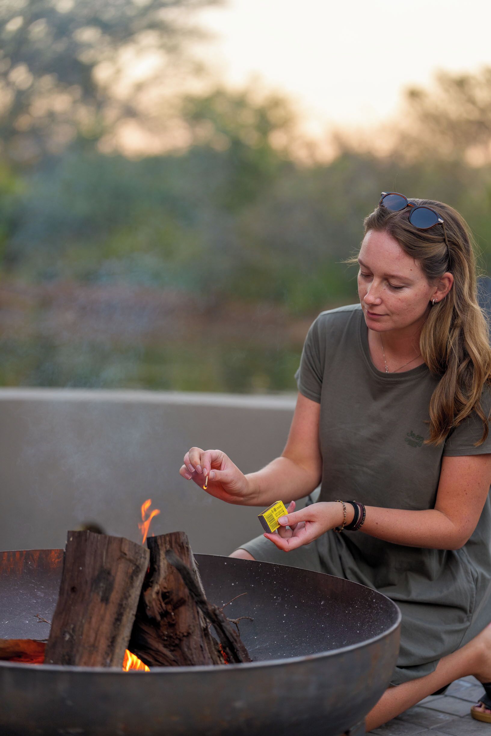 A person sitting by a fire pit outdoors.