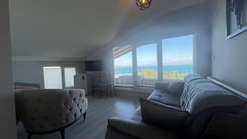 Suite estudio económica, vista al mar | Área de sala de estar
