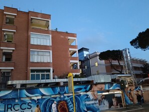 A multi-story building with a mix of residential and commercial spaces, featuring balconies and large windows. - Raffaele's Apartment: Peace and Comfort, Ideal for Small Groups and Families (Roma)