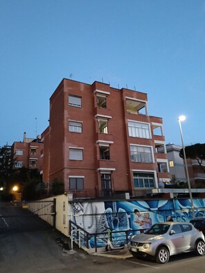 A multi-story building with balconies, a gated entrance, and a mural on the lower wall. - Raffaele's Apartment: Peace and Comfort, Ideal for Small Groups and Families (Roma)