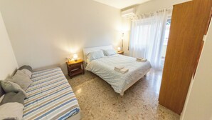 A bedroom with a bed, a bedside table with a lamp, and a window with curtains. - Raffaele's apartment, Tranquility and comfort, Suitable for small groups and families (Roma)