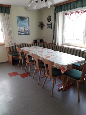 A dining area with a long table, chairs, and a bench.