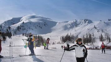 A ski slope with skiers and a chairlift.