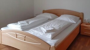 A single bed with a wooden frame, white bedding, and a nightstand with drawers. - Holiday Home 'Landlhof' with Mountain View, Private Terrace and Wi-Fi (Ramsau)