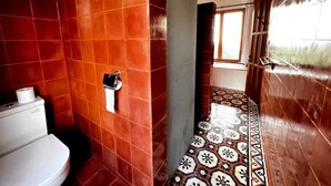 A bathroom with red tiles, a toilet, and a patterned floor. - LiRi Villa - Private villa with Magnificent ocean, jungle, valley view (Bali)