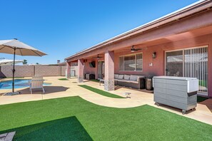 A backyard with artificial grass, a pool, outdoor furniture, and a covered patio area. - Near Golf Courses: Poolside Paradise in Yuma! (Yuma)