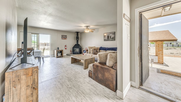 A spacious living room with a fireplace, wooden coffee table, and a sofa. - 4 Mi to Museums: Roswell Getaway w/ Game Room! (Roswell)