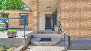 A brick building with a covered entrance, steps leading to a door, and a metal railing. - 4 Mi to Museums: Roswell Getaway w/ Game Room! (Roswell)