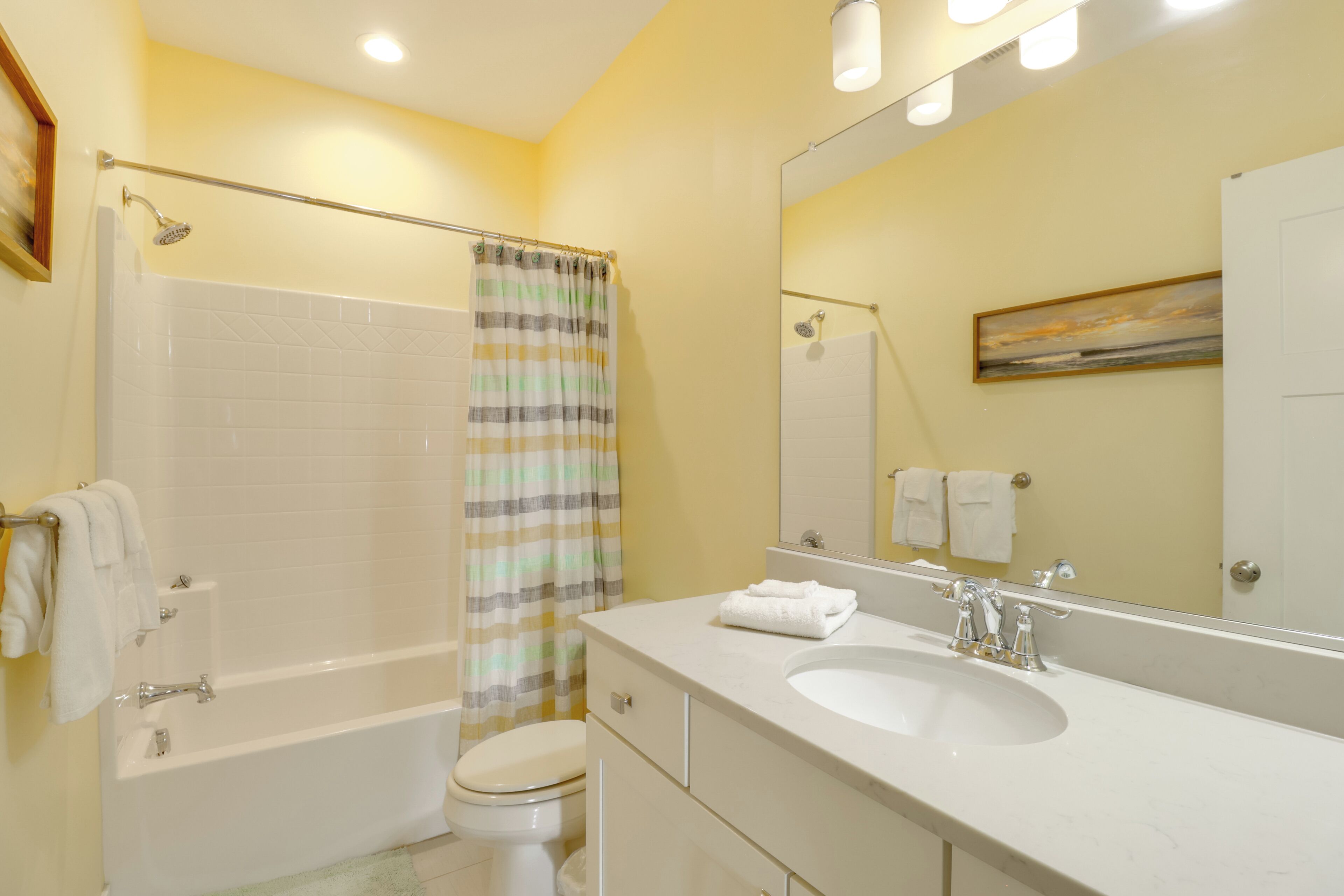 A bathroom with a bathtub, toilet, and sink.
