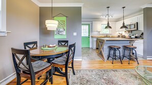 A modern kitchen with a central island, bar stools, and pendant lighting. - River Arts District Home - Walk to Downtown! (Asheville)