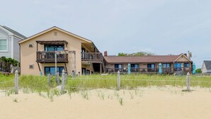 A two-story building with a balcony, a beach front sign, and a fence. - Beachfront Unit 24 in Old Orchard Beach (Old Orchard Beach)