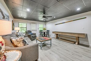 Un salon spacieux avec une grande table basse en bois, un canapé et une table de billard.