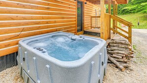 Eine Holzjagdhaus mit Whirlpool, einer Holzterrasse und einer Tür zum Innenraum.