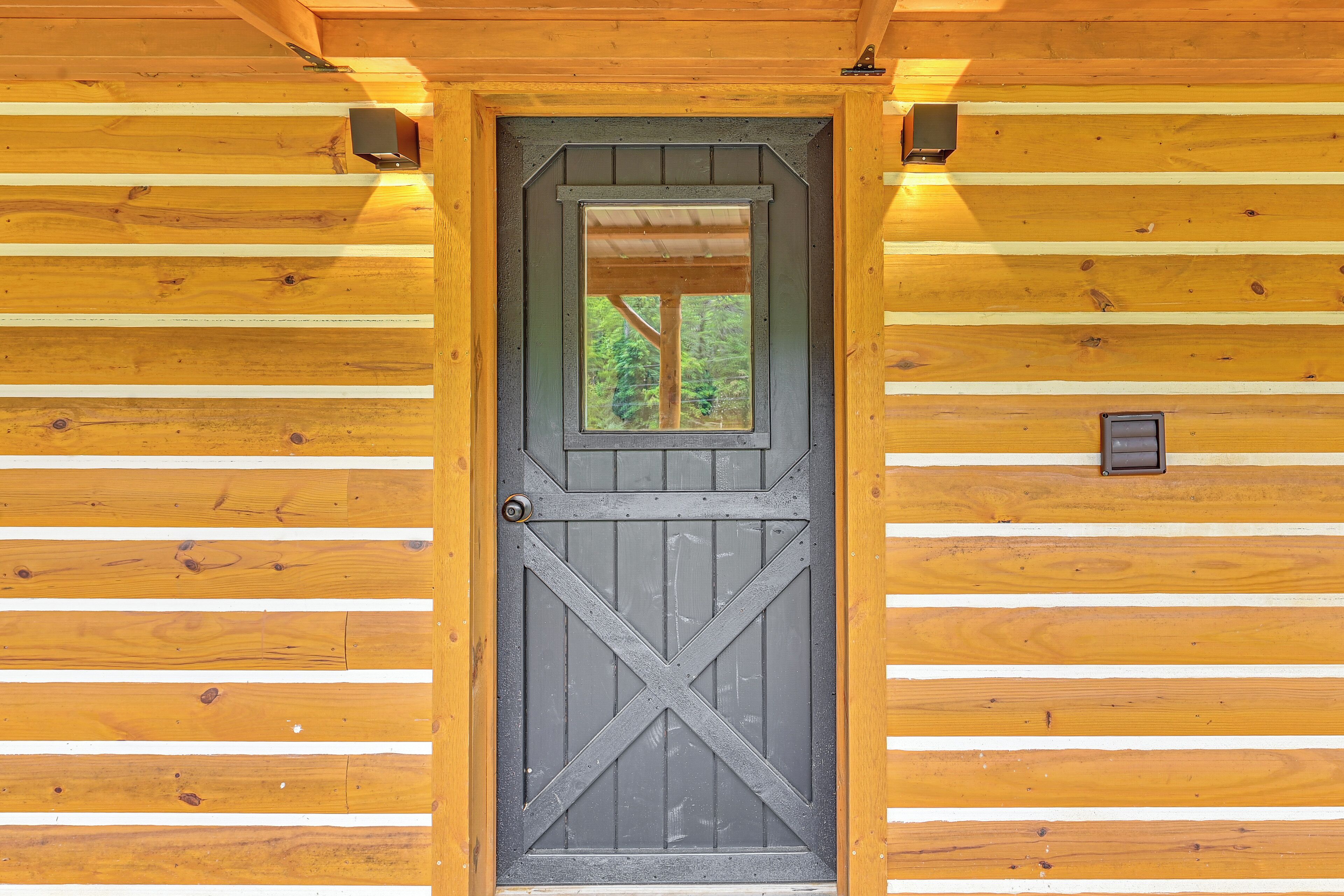 A wooden cabin door with a window above it.