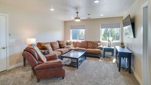A living room with a sectional sofa, a coffee table, and a TV on a stand. - Missouri River Retreat < 1 Mi to the Water! (Pierre)