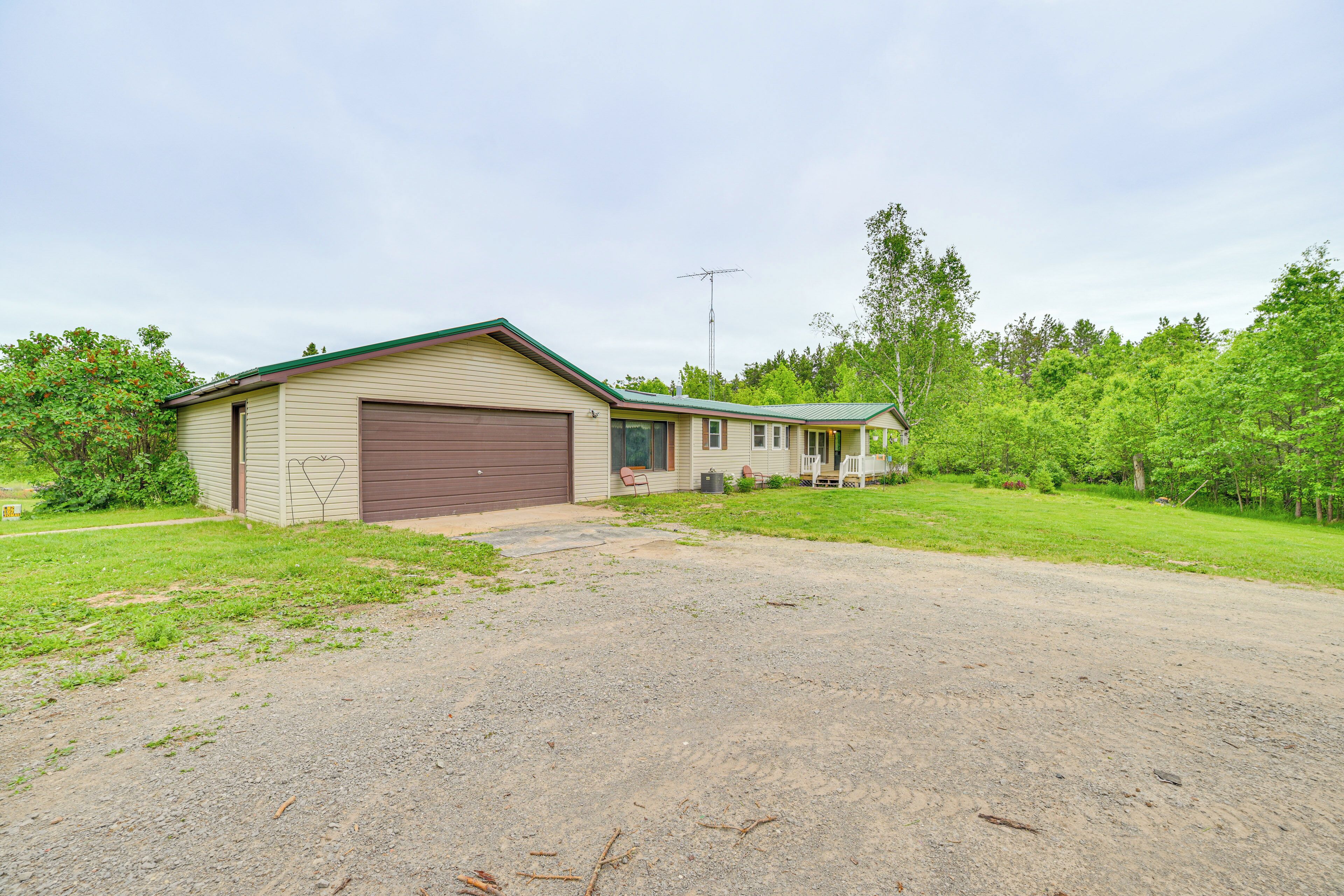 Ett enplanshus med ett garage och en liten veranda.