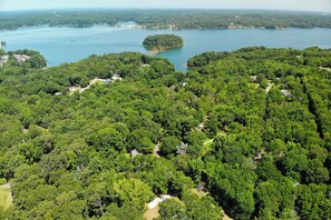 An aerial view of a forested area with a lake, a small island, and scattered buildings. - 1 Mi to Lake Hartwell: Updated Retreat w/ Patio! (Anderson)