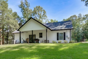Ein eingeschossiges Haus mit überdachter Veranda, Eingangstür und kleinem Vorgarten.