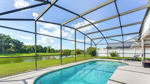 A covered swimming pool with a view of a lake and greenery. - 6 Mi to Disney World: Lake-view Retreat w/ Pool! (Kissimmee)