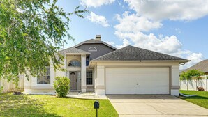 A two-story house with a garage, a front yard, and a mailbox. - 6 Mi to Disney World: Lake-view Retreat w/ Pool! (Kissimmee)