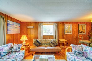 A cozy room with wooden walls, a sofa, two armchairs, a small table, and a window with curtains. - 4 Mi to Off-road Park: Beckley Area Townhome (Sophia)