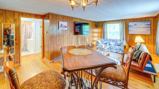 A wooden-paneled room with a dining table, chairs, a sofa, and a television. - 4 Mi to Off-road Park: Beckley Area Townhome (Sophia)