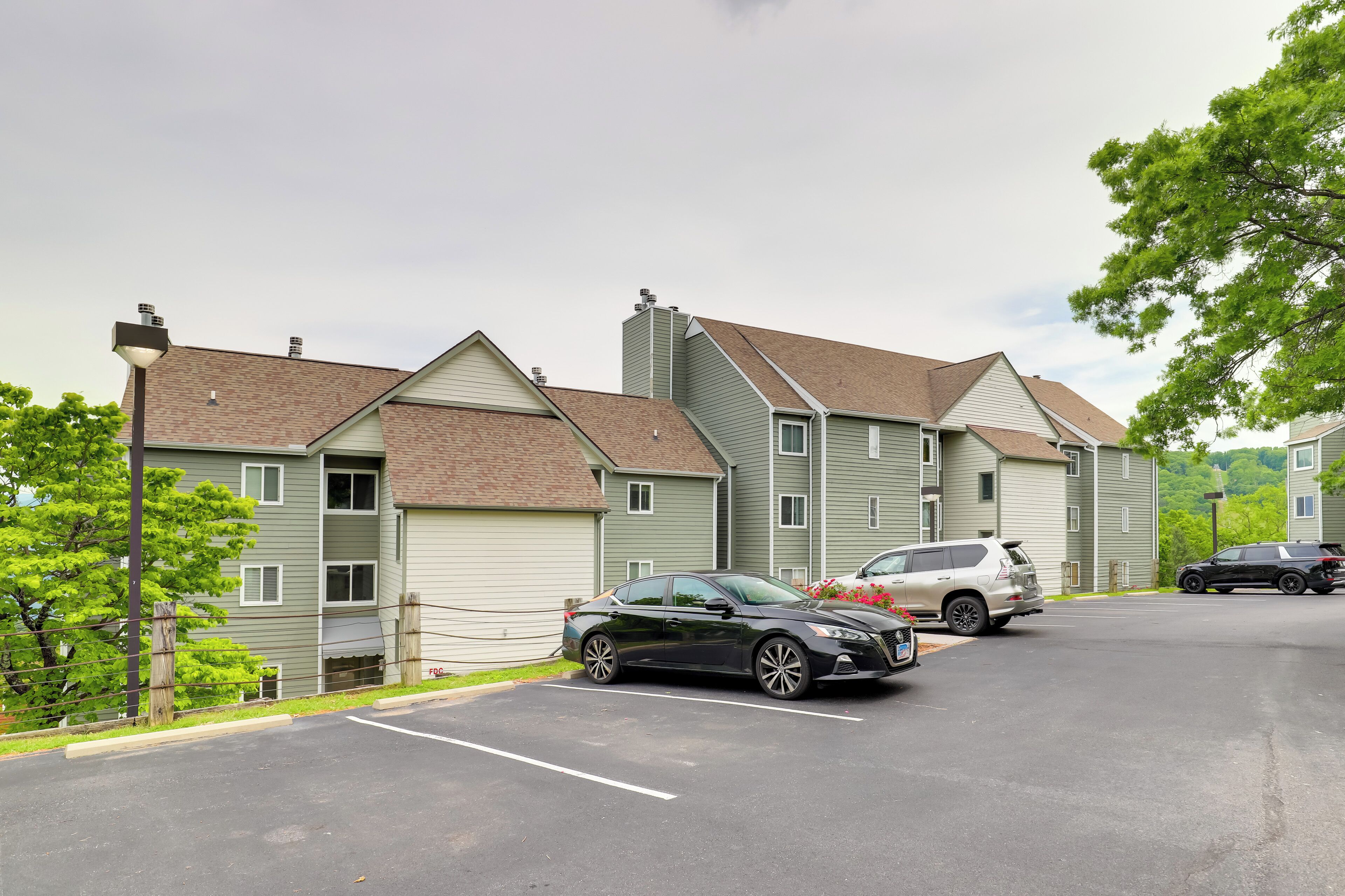 A row of townhouses with a parking lot in front.
