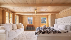 Una habitación acogedora con un sofá blanco, una cama con cabecera blanca y una alfombra mullida.