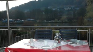 A table set outdoors with a view of a lake and forest. - Holiday Home 'Altmühltal Beilngries' with Mountain View, Private Terrace and Wi-Fi (Beilngries)