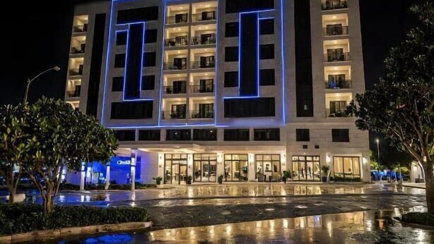 A modern hotel with a central courtyard and reflective water feature.