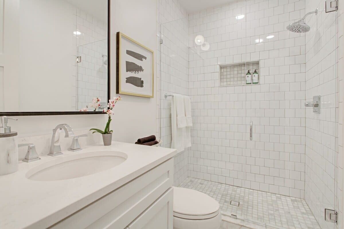 A modern bathroom with a large sink, a toilet, and a shower area.