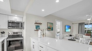 A modern kitchen with a built-in microwave, oven, and a large island with seating.