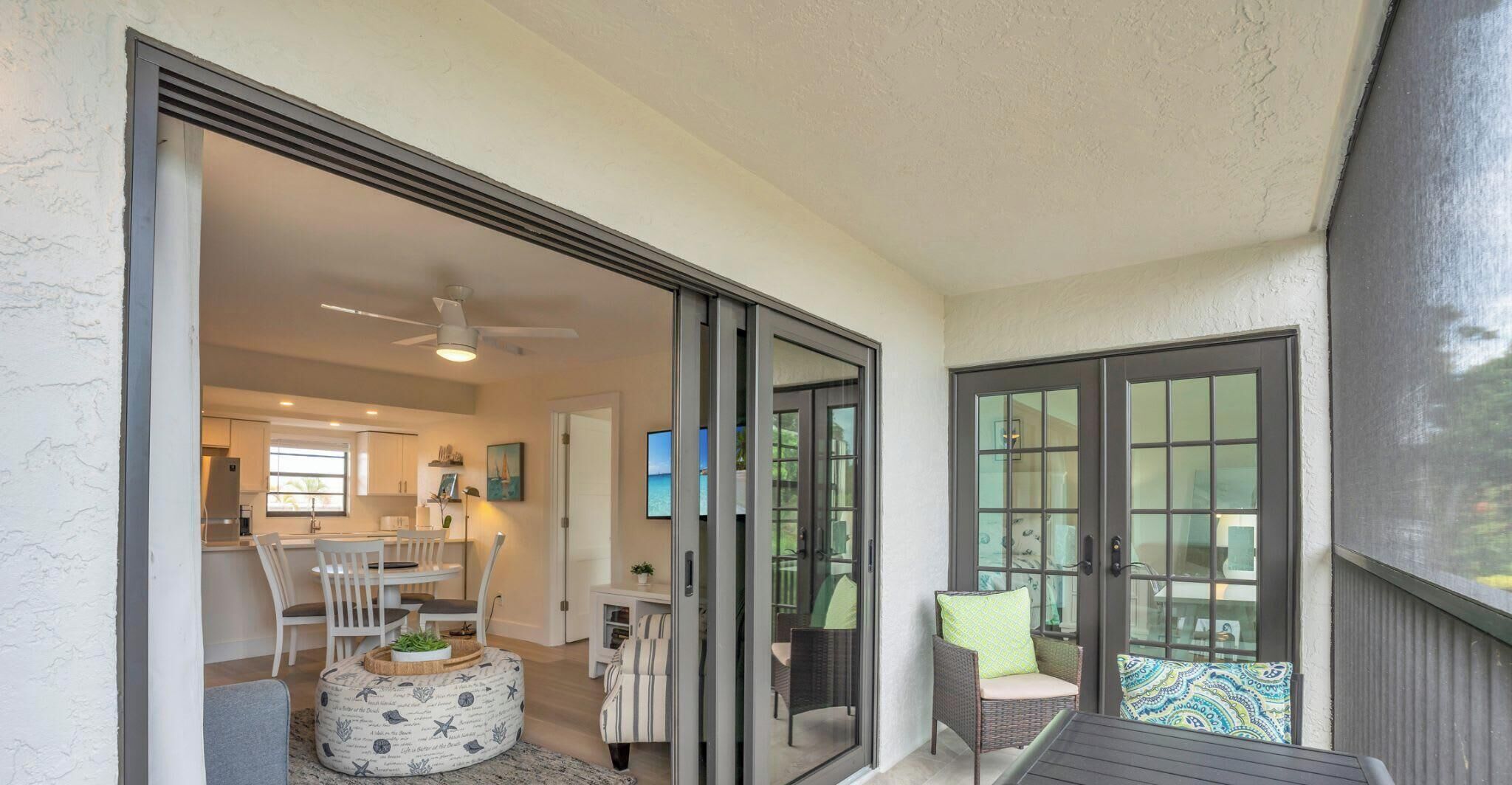 A residential interior with a dining area, kitchen, and a sliding glass door leading to a balcony.