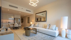 A modern living room with a sofa, coffee table, and dining area.