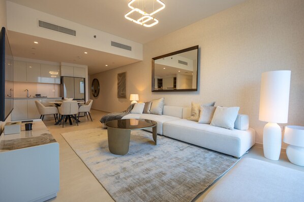 A modern living room with a sofa, coffee table, and dining area.