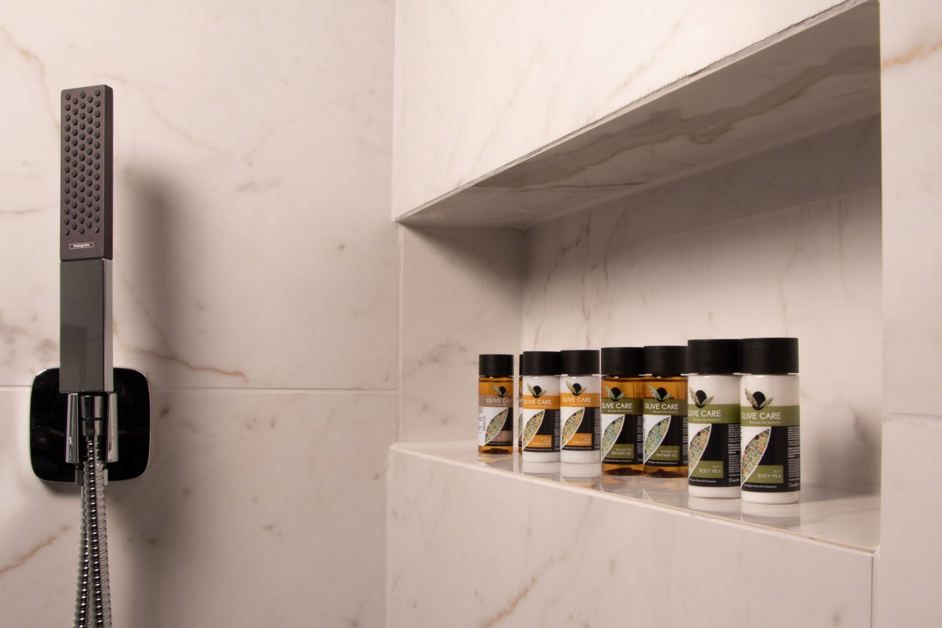 Een badkamer met een douche en planken met verzorgingsproducten.