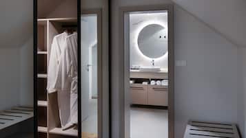 A modern bathroom with a round mirror, a sink, and a towel rack.