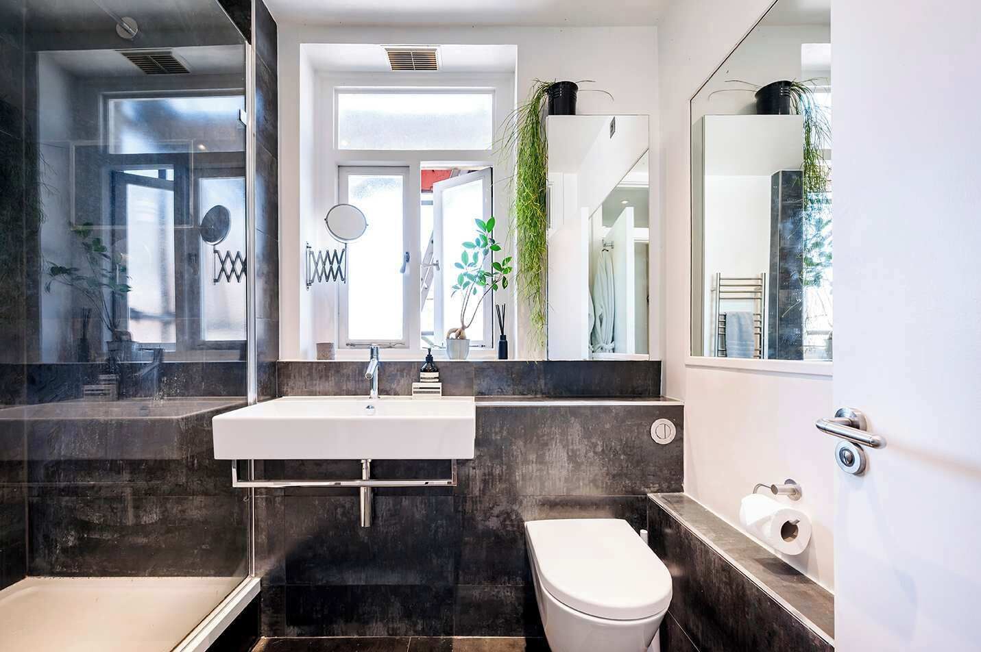 Une salle de bain moderne avec un lavabo blanc, des toilettes et un espace douche.