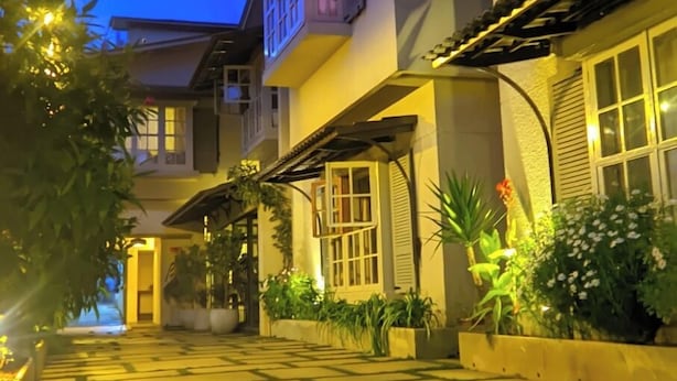 A two-story building with a covered walkway and potted plants.