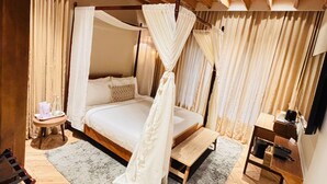 A bedroom with a four-poster bed, a small bedside table, a nightstand, and a wooden bench.