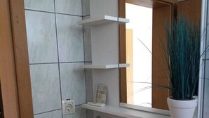 A bathroom with a white sink, a mirror above it, and a potted plant on a shelf. - Charming bed & breakfast with 9 bedrooms and WiFi, AC in enchanting Međugorje (Međugorje)