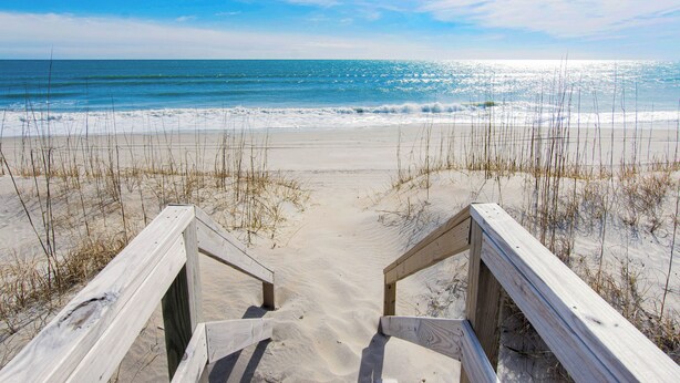 A wooden boardwalk leading to a sandy beach with ocean views. - Oceanfront 4BR Cottage w/ Sunroom and covered porch for the best views (Emerald Isle)
